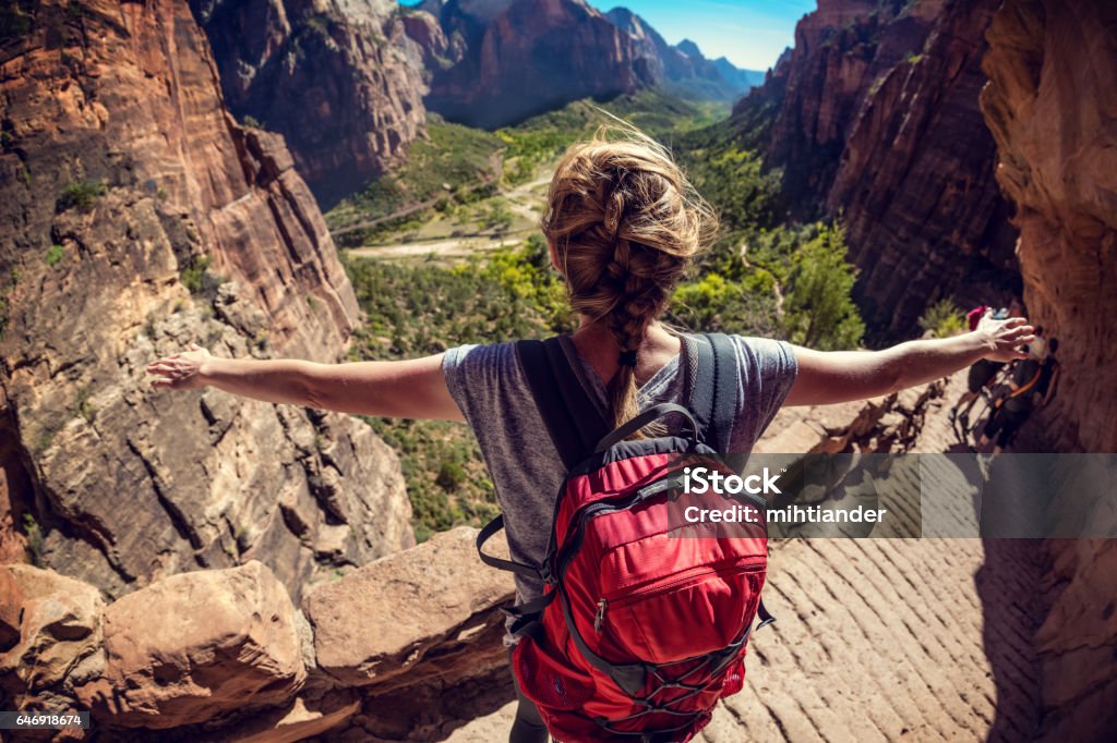 Woman hiker standing with raised hands Woman hiker standing with raised hands and watching valley view of Zion National Park, USA Hiking Stock Photo