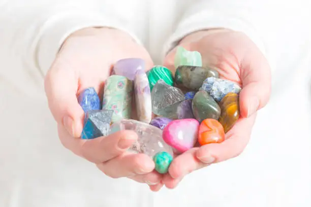Multiple semi precious gemstones in hands
