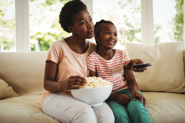 mãe e filha assistindo televisão na sala de estar - popcorn snack bowl isolated - fotografias e filmes do acervo