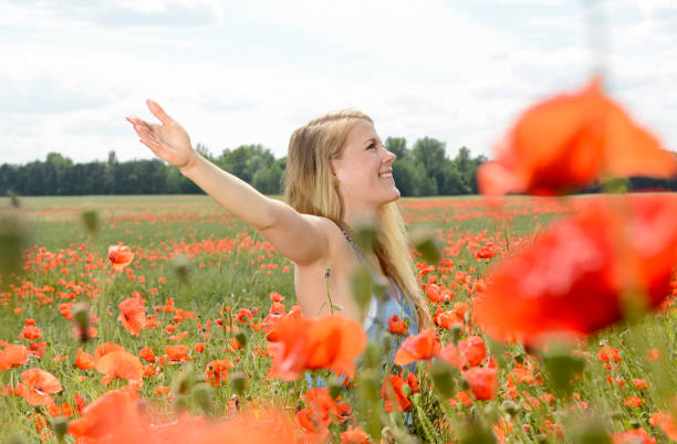 istock woman cheering in poppy field 646927652