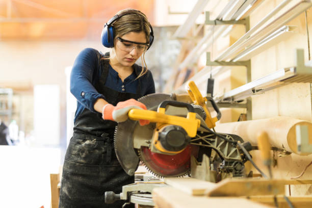 frau mit elektrowerkzeugen in einem woodshop - slicing machine stock-fotos und bilder