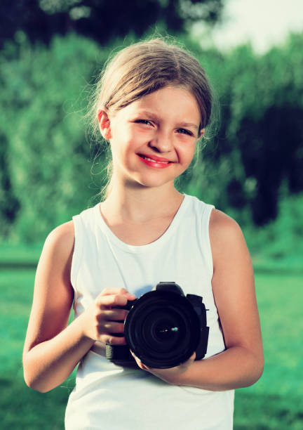 istock girl  holding photo camera 646930268
