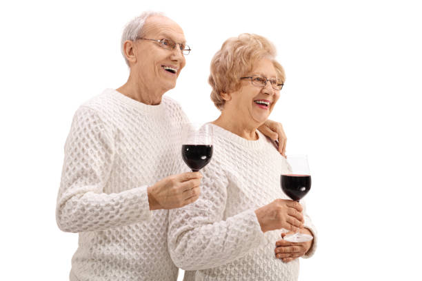 Joyful elderly couple with glasses of wine isolated on white background