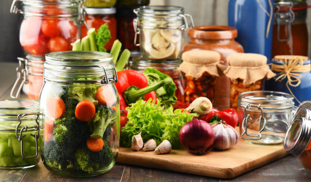 istock Jars with marinated food and raw vegetables on cutting board 646938388