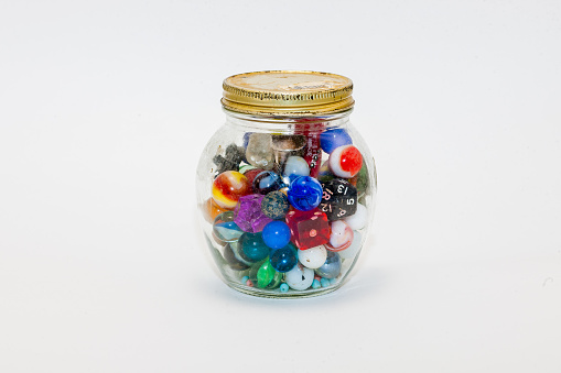 Glass spheres, marbles, transparent with color inside, in glass jars. Selective focus. Macro photography.