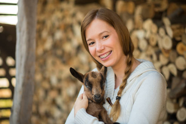istock Eastern Europe: Lifestyle-Young woman hugging kid goat 646942500