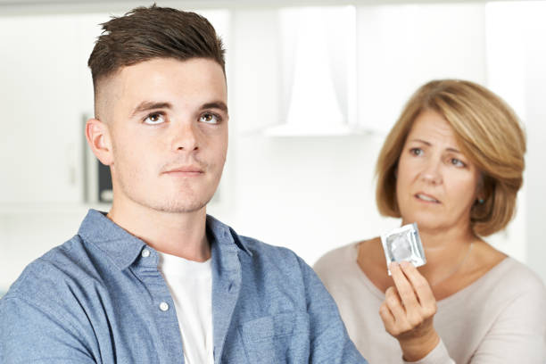 madre hablando con hijo adolescente sobre la anticoncepción - teenage sex fotografías e imágenes de stock