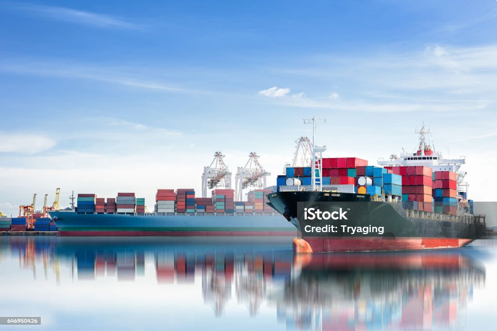 International Container Cargo ship with working crane bridge in seaport International Container Cargo ship with working crane bridge in shipyard background, logistic import export background and transport industry. Container Ship Stock Photo
