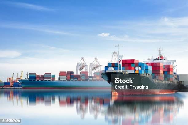 International Container Cargo Ship With Working Crane Bridge In Seaport Stock Photo - Download Image Now