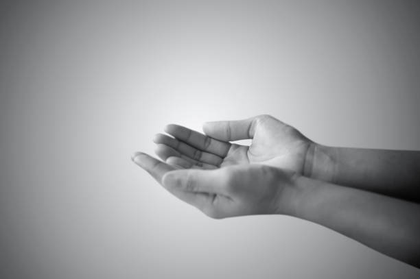 istock hand of man praying and asking in white and black 646951434