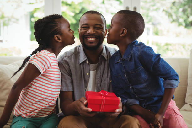 istock Son and daughter kissing father 646954300