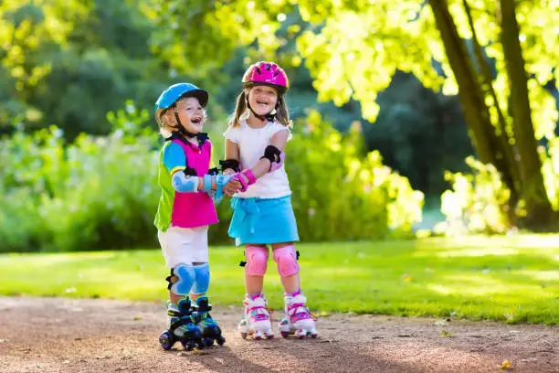 Photo of Kids roller skating in summer park