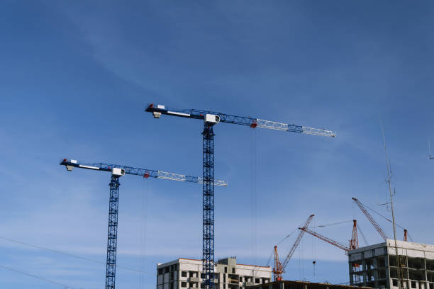 istock Crane and building under construction against blue sky 646959968