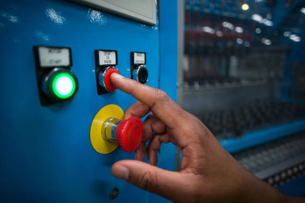 istock Hands of factory worker pressing a red button on the control board 646980904