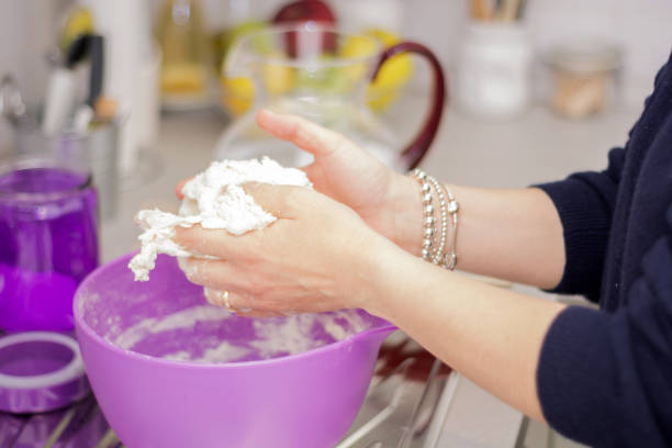 istock female hands in flour kneading dough on table 646981836