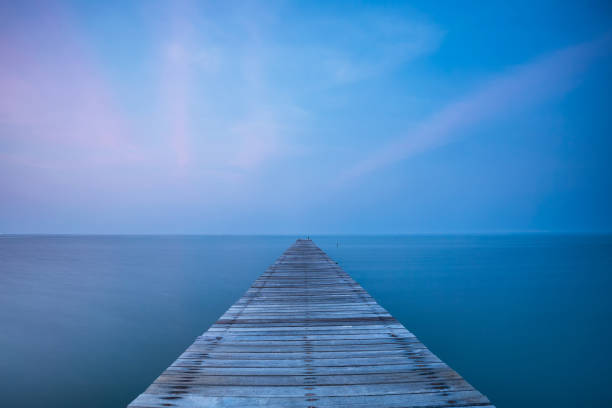 istock Wooden bridge on sea at sunset 647004662