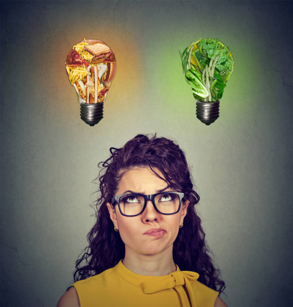 istock Woman looking up at junk food vegetables light bulb 647022108