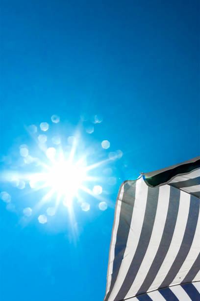 istock High resolution beach umbrella on blue sky background 647022798