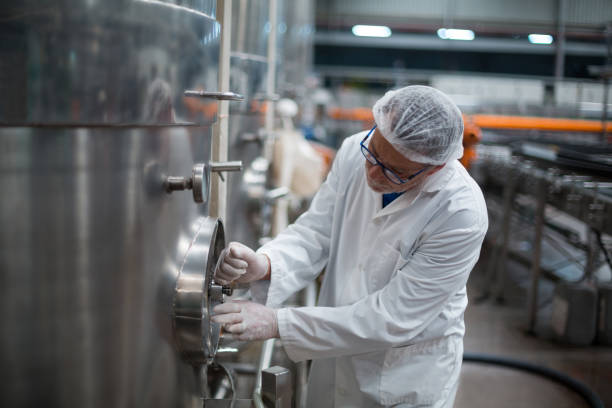 istock Factory engineer turning control wheel of storage tank 647025626