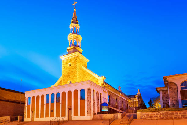 Notre Dame du Portage Church in Downtown Kenora Ontario Canada Stock photo of the illuminated Notre Dame du Portage Catholic Church in downtown Kenora, Ontario, Canada, at twilight blue hour. kenora stock pictures, royalty-free photos & images