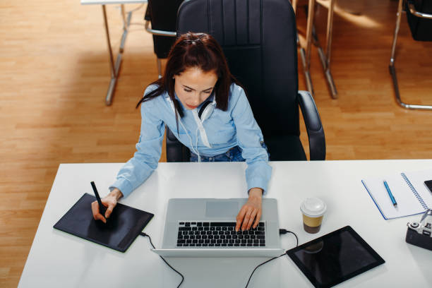 istock Young woman designing on laptop at the office 647029192