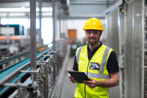 istock Portrait of smiling factory worker using a digital tablet 647035862
