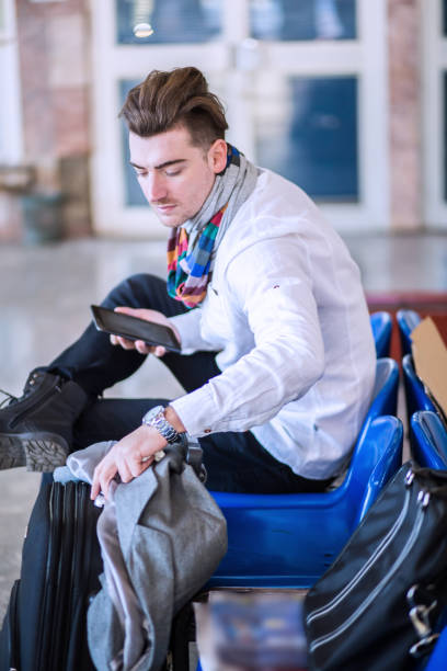 istock Young men holding a bag in railroad station 647047046