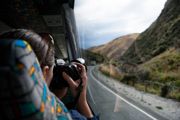 Tourist aboard bus photographing the country of New Zealand stock photo