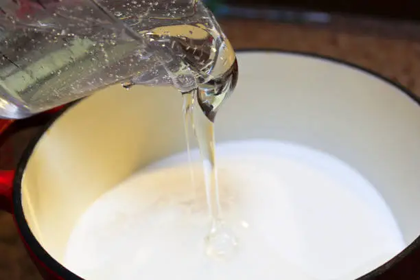 Pouring Corn Syrup into a Pot to Make Hard Candy.