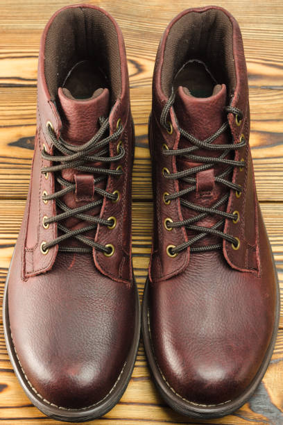 istock Stylish brown leather boots for men on wooden background. 647083638