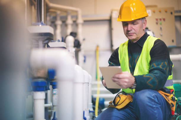 tecnico in locale caldaia con tablet pc - boiler fuel pump pipe engineering foto e immagini stock