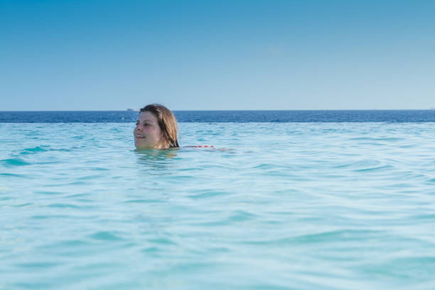 istock Lady Enjoys Bathing in the Beach 647084512