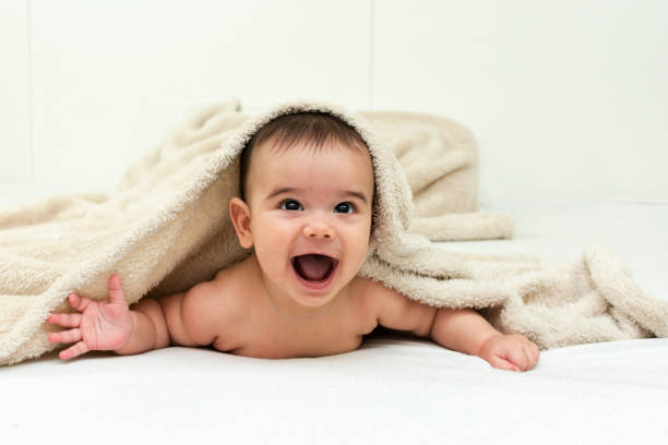 istock Cute baby boy in bed under a fluffy blanket 647090230