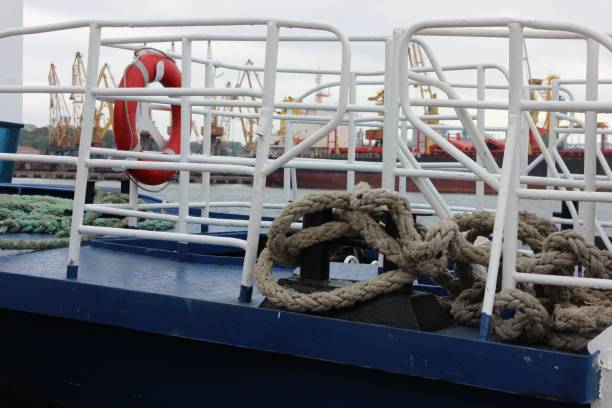 istock Blue boat deck with white fence, red life ring and thick jute rope. 647090468