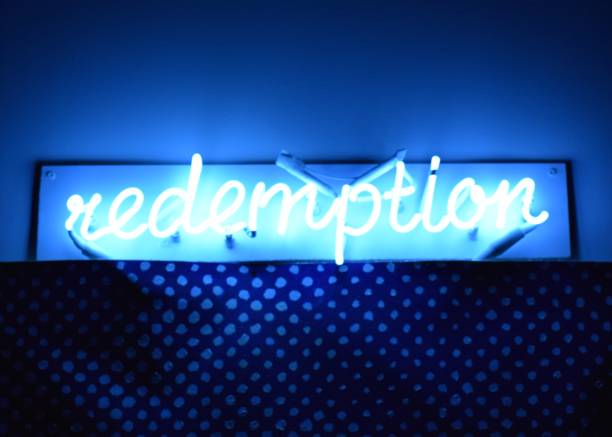 istock Neon Sign Illuminates the Word Redemption 647091032