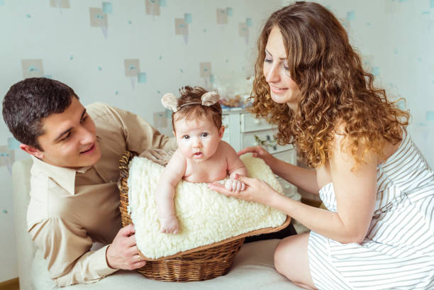 bebé sentado en una canasta de mimbre - two parent family naked men couple fotografías e im�ágenes de stock