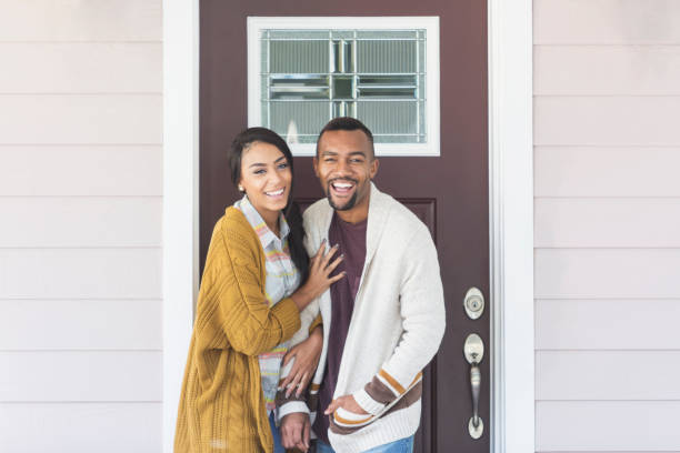 Young mixed race couple standing by front door
