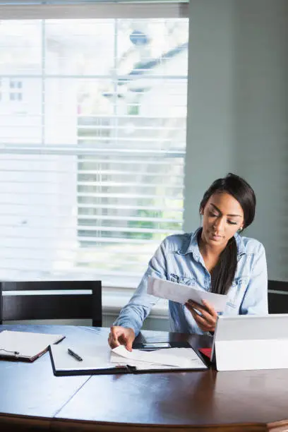 Photo of Young woman working from home or paying bills