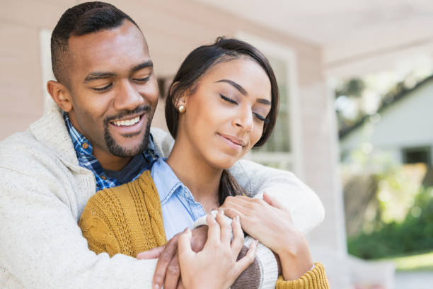 istock Affectionate young mixed race couple on front porch 647095966