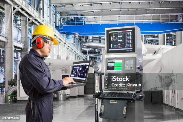 Engineer Using Computer For Maintenance Equipment In Powerhouse Stock Photo - Download Image Now