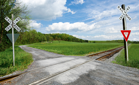 A narrow gravel road crosses a set of railroad tracks in rural Virginia.