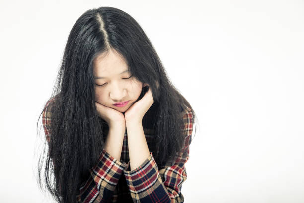 Chinese teenager sad with head in hands