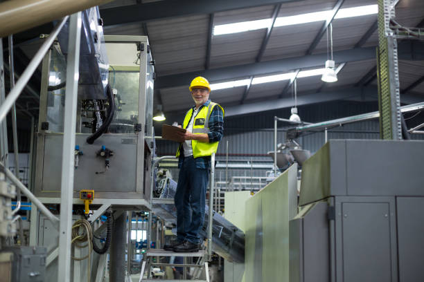 istock Male factory worker maintaining record on clipboard 647106584