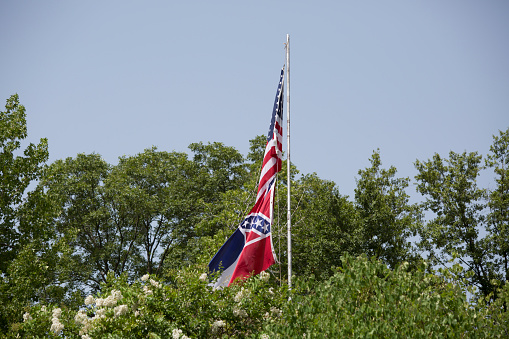 United States and Mississippi state flags flowing in the wind