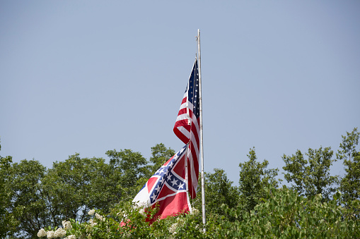 United States and Mississippi state flags flowing in the wind