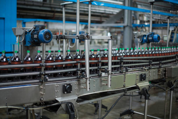 istock Bottles of juice on conveyer belt 647113236