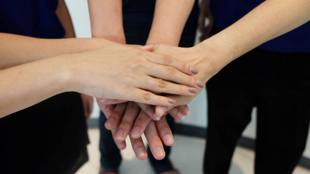 istock business team showing unity with putting their hands togethe 647117122