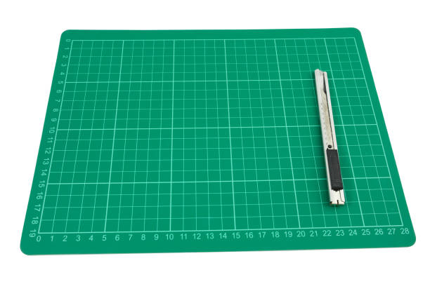 istock Green cutting mat with cutter on white background 647117142
