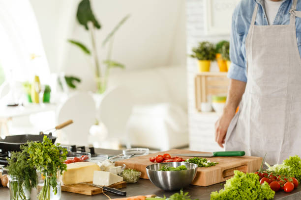 istock Man in the kitchen, preparing vegetables salad 647123684