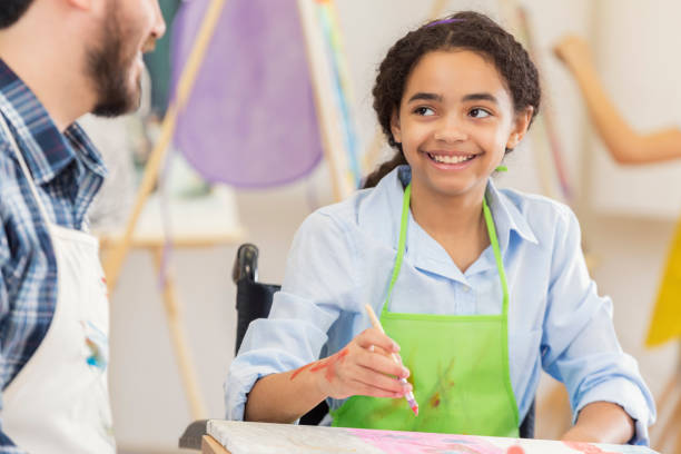 istock Art teacher works with preteen student 647137970